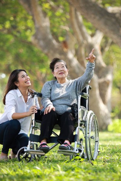 asian-senior-woman-sitting-wheelchair-with-her-daugther-family-happy-smile-face-green-park-v